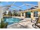 A gorgeous screened pool with a travertine deck and water feature adjoins the sliding glass door at 7885 Se 166Th Hibernia Ln, The Villages, FL 32162