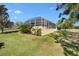 Screened pool area with well-maintained landscaping and clear blue skies creating the perfect backyard retreat at 7885 Se 166Th Hibernia Ln, The Villages, FL 32162