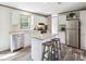 Well-lit kitchen featuring an island, stainless steel appliances, and wood-look floors at 9060 Sarah Dr, Polk City, FL 33868