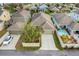 Aerial view of a home featuring a driveway, green grass, and a small pool in the backyard at 909 Egrets Landing Way, Groveland, FL 34736