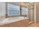 Bathroom featuring a tub and a separate glass-enclosed shower at 909 Egrets Landing Way, Groveland, FL 34736