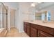 Bathroom with double sinks, tile flooring, and glass-door shower at 909 Egrets Landing Way, Groveland, FL 34736