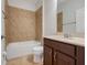 Bathroom featuring tile flooring, single sink vanity, a mirror, and a shower-tub combo at 909 Egrets Landing Way, Groveland, FL 34736