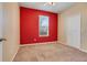 Bedroom with carpet flooring, red accent wall, a window with blinds and a closet at 909 Egrets Landing Way, Groveland, FL 34736