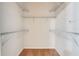 Empty walk-in closet featuring carpet flooring, white walls and multiple white wire rack shelves at 909 Egrets Landing Way, Groveland, FL 34736