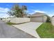 View of a home's driveway and garage, with a fence and green grass nearby at 909 Egrets Landing Way, Groveland, FL 34736