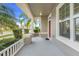 Inviting front porch featuring an elegant white railing and columns at 909 Egrets Landing Way, Groveland, FL 34736