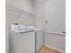 Laundry room featuring tile flooring, a wire rack shelf, a washer, and a dryer at 909 Egrets Landing Way, Groveland, FL 34736