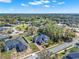 Expansive aerial view of estate home surrounded by lush greenery and well-manicured lawns under a sunny sky at 9513 Mid Summer Ln, Leesburg, FL 34788