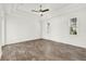 Light-filled bedroom with wood floors, a ceiling fan, and multiple windows at 9513 Mid Summer Ln, Leesburg, FL 34788