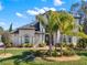 Inviting front exterior of home with beautiful landscaping, brick pathway, and an elegant arched doorway at 9513 Mid Summer Ln, Leesburg, FL 34788