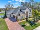 Stunning two-story home with lush landscaping, brick driveway, and a spacious three-car garage at 9513 Mid Summer Ln, Leesburg, FL 34788