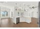 Open-concept kitchen featuring stainless steel appliances, quartz countertops, and white cabinetry at 9513 Mid Summer Ln, Leesburg, FL 34788