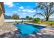 Backyard pool featuring a brick-lined pool deck, lovely landscaping, and a secure fence at 9513 Mid Summer Ln, Leesburg, FL 34788