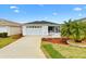 Charming single-story home with a well-manicured lawn, white picket fence, and attached garage at 993 Davit Pl, The Villages, FL 32162