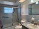 Bathroom featuring tiled walls, a shower with sliding doors, marble counter top, and natural light at 1009 Linda Glen Ave, Fruitland Park, FL 34731