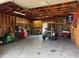 Spacious garage featuring a golf cart, lawn mower, workbench, and storage shelving at 1009 Linda Glen Ave, Fruitland Park, FL 34731