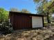 Detached garage with a white garage door, exterior lighting, and mature trees at 1009 Linda Glen Ave, Fruitland Park, FL 34731