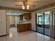 Bright kitchen with white tile flooring, wooden cabinets, and a sliding door to the patio at 1009 Linda Glen Ave, Fruitland Park, FL 34731