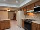 Cozy kitchen featuring wooden cabinets, white appliances, and a view to the dining area at 1009 Linda Glen Ave, Fruitland Park, FL 34731