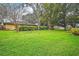 Backyard featuring lush green space and privacy hedges, perfect for outdoor activities and relaxation at 10122 Canterbury Dr, Leesburg, FL 34788