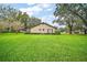 View of the property from backyard with a large manicured lawn at 10122 Canterbury Dr, Leesburg, FL 34788