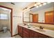 Bathroom with a double sink vanity, tiled floors, and an adjacent toilet room at 10122 Canterbury Dr, Leesburg, FL 34788