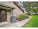 Brick home exterior featuring a modern AC unit, neat landscaping, and a well-maintained yard at 10122 Canterbury Dr, Leesburg, FL 34788