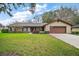 Charming brick home with a well-manicured front yard and a two car garage at 10122 Canterbury Dr, Leesburg, FL 34788