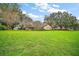 Expansive front yard with mature trees framing a charming single-story home at 10122 Canterbury Dr, Leesburg, FL 34788