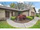 Close up on front yard with a brick facade, landscaped yard, and a walkway at 10122 Canterbury Dr, Leesburg, FL 34788