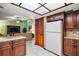 Bright kitchen features dark cabinets, white appliances, and tile flooring at 10122 Canterbury Dr, Leesburg, FL 34788