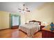 Comfortable bedroom with hardwood floors, ceiling fan, and a bench by the window at 10122 Canterbury Dr, Leesburg, FL 34788