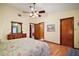 Main bedroom featuring a ceiling fan, hardwood floors, and ensuite bathroom at 10122 Canterbury Dr, Leesburg, FL 34788