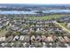 Expansive aerial view of a well-planned community featuring homes, landscaping, and a large lake in the background at 112 Flame Vine Way, Groveland, FL 34736