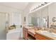 Bathroom with double sinks, walk in shower and a stand alone bath tub at 112 Flame Vine Way, Groveland, FL 34736