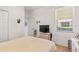 Bright bedroom features a window, TV, and wicker nightstand at 112 Flame Vine Way, Groveland, FL 34736