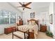 Bedroom featuring plush bedding, a ceiling fan and multiple windows at 112 Flame Vine Way, Groveland, FL 34736
