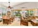 Bright dining room with a large table, ample seating, and sliding glass doors to the sunroom at 112 Flame Vine Way, Groveland, FL 34736