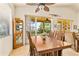 Close up of a dining room with a large table, ample seating, and sliding glass doors at 112 Flame Vine Way, Groveland, FL 34736