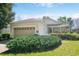 Charming single Gathering home featuring a two-car garage, mature landscaping, and neutral paint scheme at 112 Flame Vine Way, Groveland, FL 34736