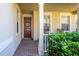 Inviting covered front porch with a brick walkway, decorative wreath, and cozy seating area at 112 Flame Vine Way, Groveland, FL 34736