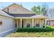 A cozy front porch with white columns and well-manicured landscaping at 112 Flame Vine Way, Groveland, FL 34736
