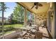 Outdoor patio with screened-in porch, ceiling fan and a dining table and view of backyard at 112 Flame Vine Way, Groveland, FL 34736