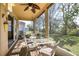 Screened in patio with a dining table, ceiling fan and view to the backyard at 112 Flame Vine Way, Groveland, FL 34736