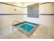 A well-maintained indoor spa room with a hot tub and tiled walls at 112 Flame Vine Way, Groveland, FL 34736