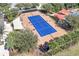 Aerial view of a tennis court shaded by palms and sunshades ready for the next match at 112 Flame Vine Way, Groveland, FL 34736