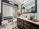 Stylishly decorated bathroom with black and white accents and a combination shower and tub at 1131 Apple Ter, Leesburg, FL 34748