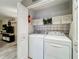 Convenient laundry area with washer, dryer, storage shelves, and stylish decor at 1131 Apple Ter, Leesburg, FL 34748