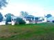 Inviting single-story home with a cozy porch, a metal roof, and a well-maintained lawn at 11428 Pheasant Trl, Leesburg, FL 34788